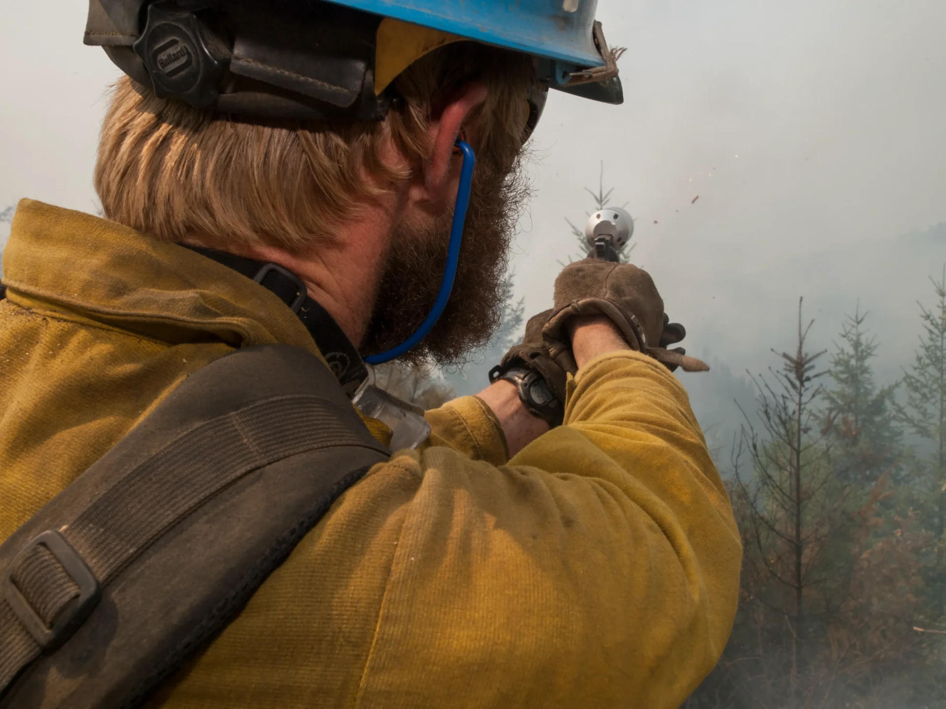 Firefighter controlling wildfire with flare gun